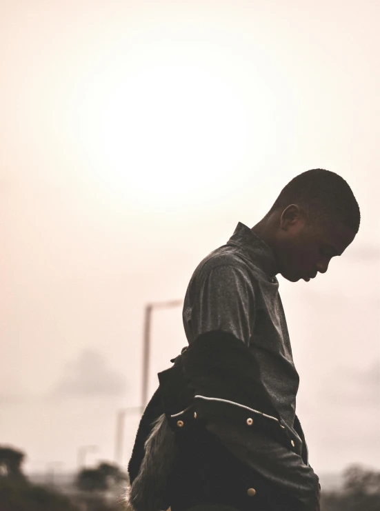 man with a backpack looking down in front of a sun