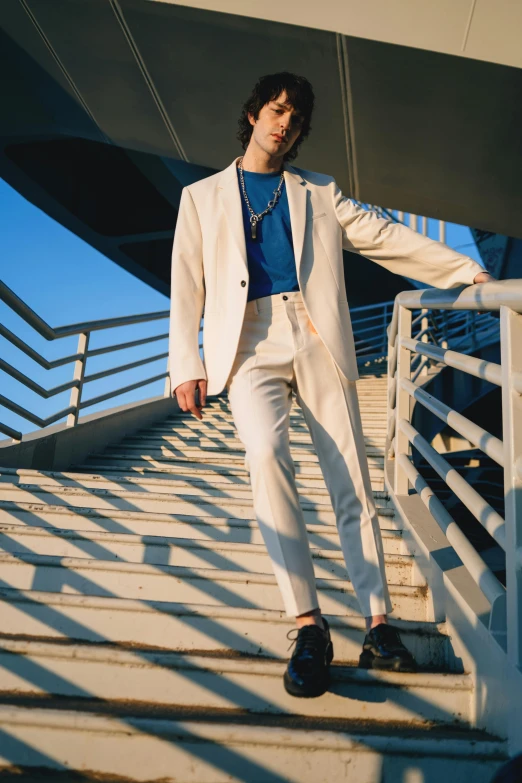 a person standing on a staircase wearing a white suit