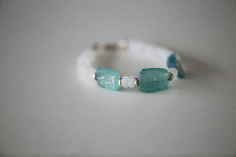 a white and turquoise beaded ring on a table