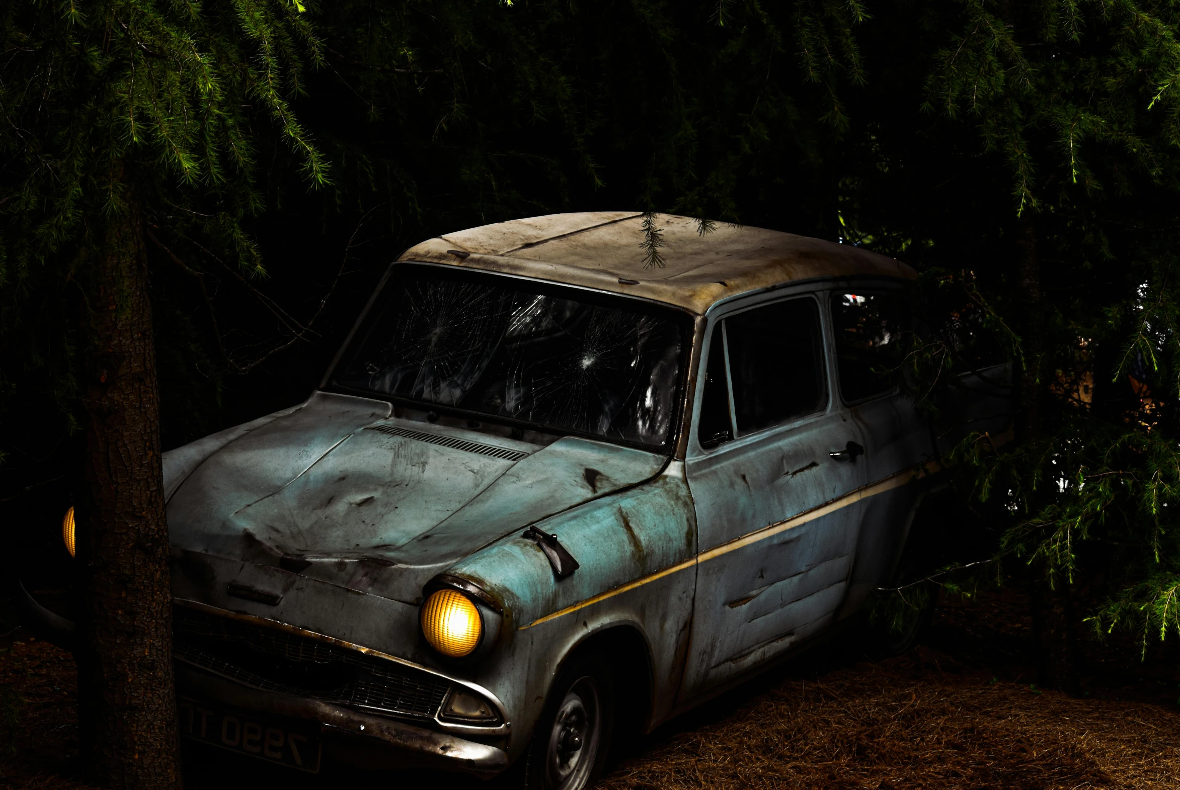 an old dirty car sitting in a wooded area