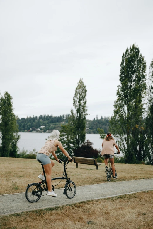 two women riding bicycles, one with a trailer