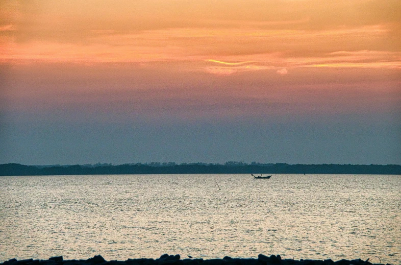 a person standing on a beach at sunset