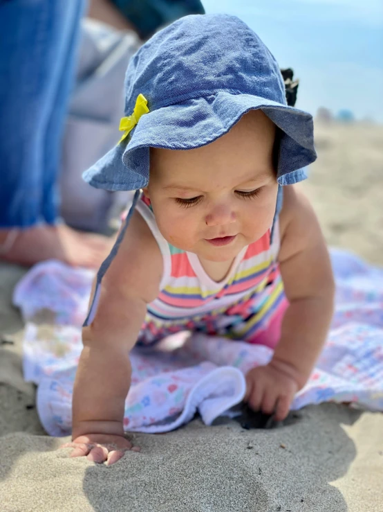 there is a baby in a hat crawling on a blanket