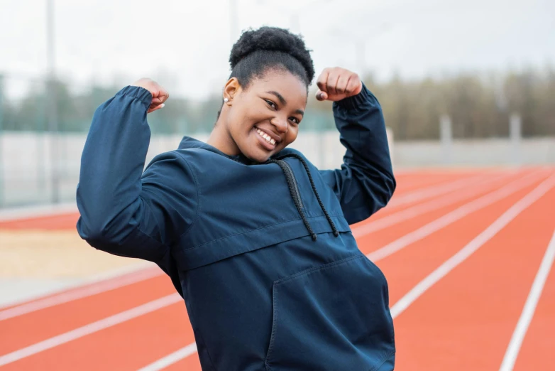 a beautiful young black woman standing on top of a track