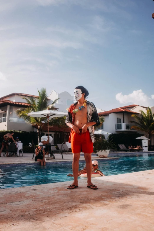 a man wearing a mask and a towel by the pool