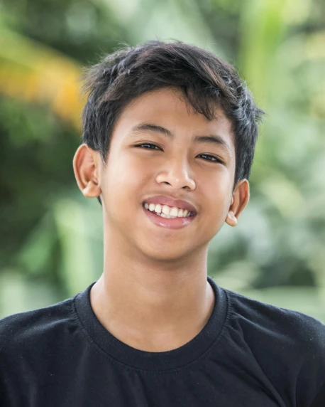 a boy with short hair smiles into the camera