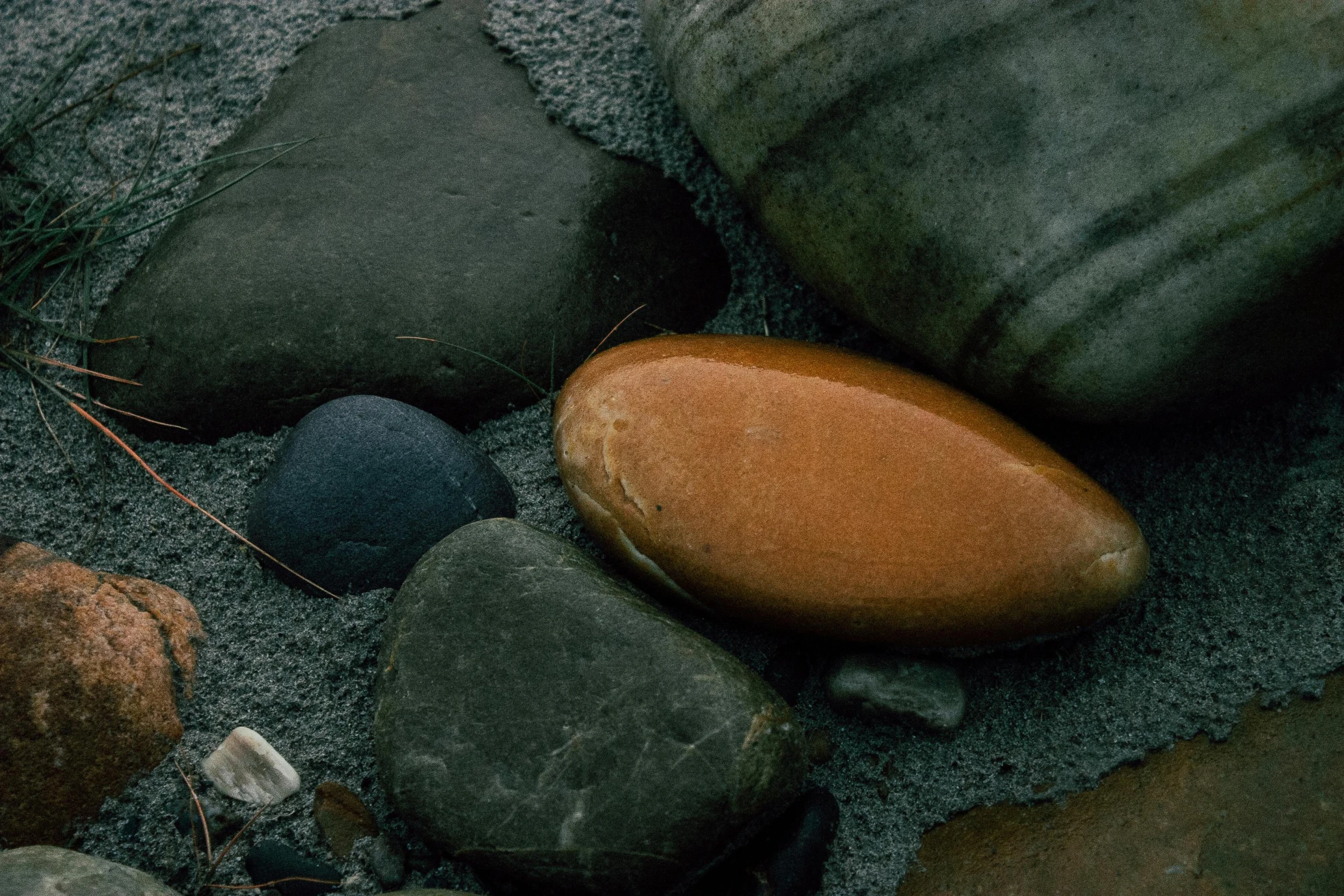 a group of rocks and pebbles on the beach