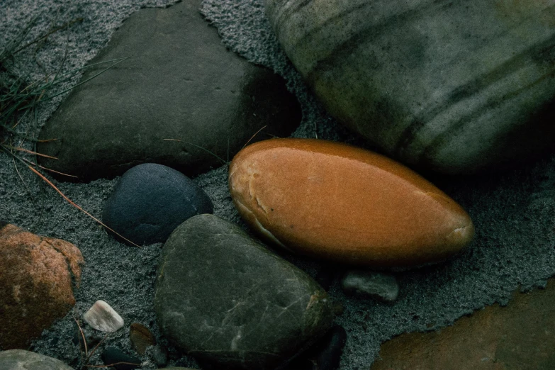 a group of rocks and pebbles on the beach