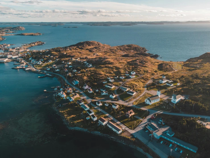 an aerial view of a village with a long beach next to it