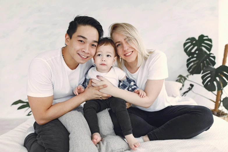 two people and a small child on the bed