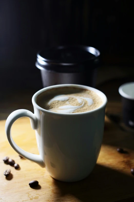 a cup of coffee on a table with some coffee beans