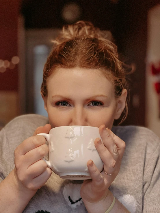 a woman drinking a coffee cup of a coffee shop