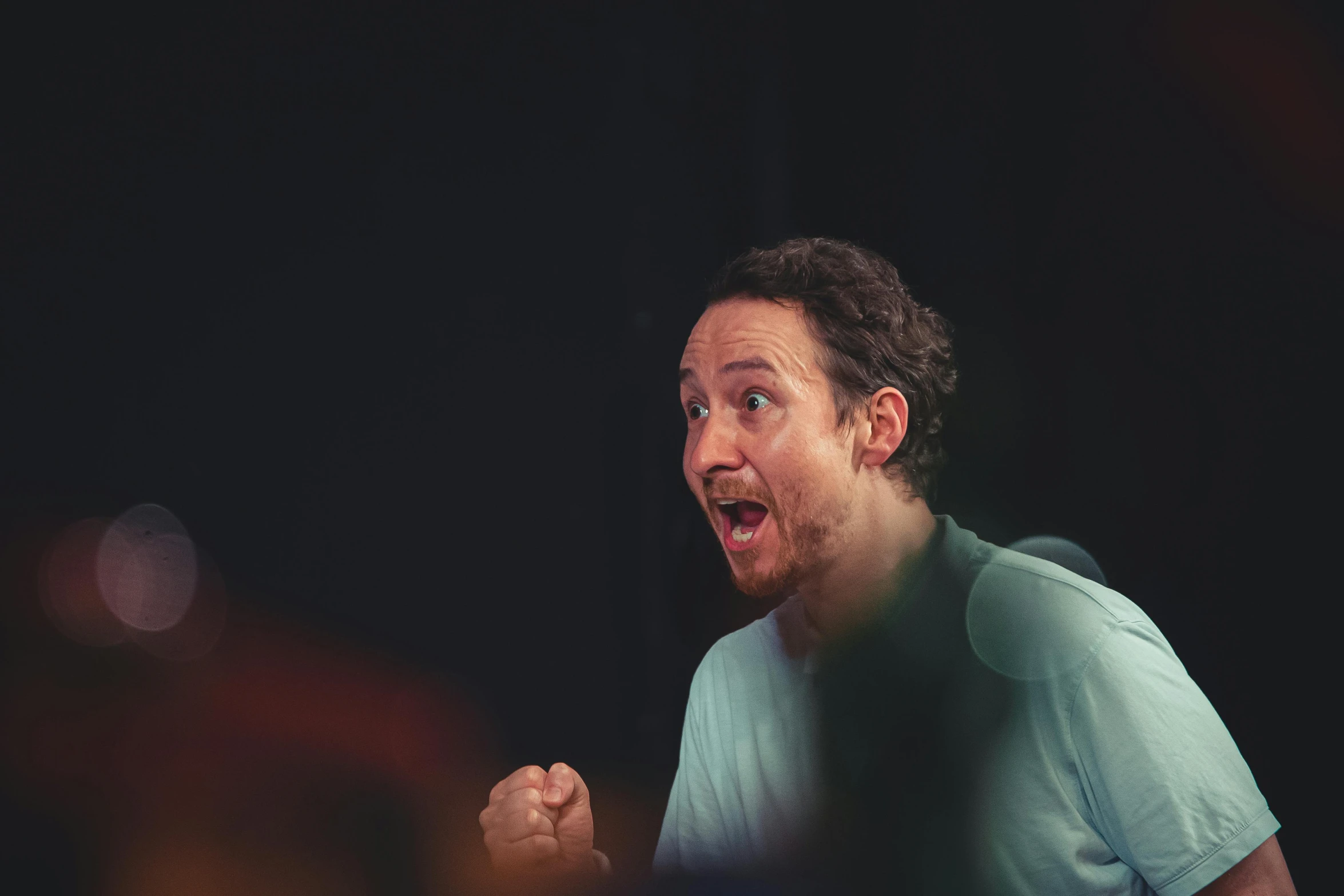 a man in a t - shirt holding a tennis racket