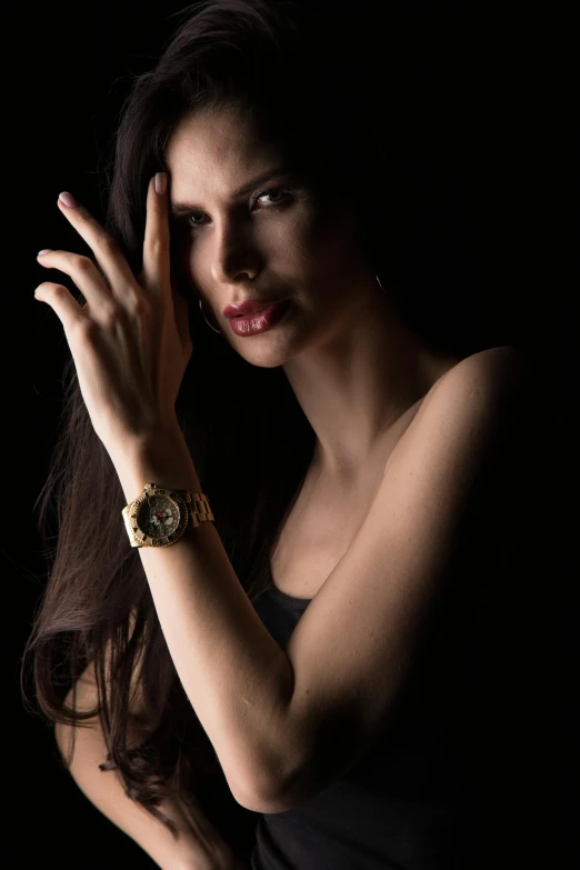 a woman wearing a black dress with a watch on her wrist