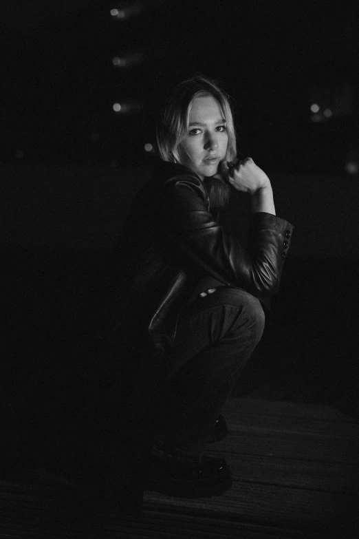 a black and white po of a person kneeling down in the dark