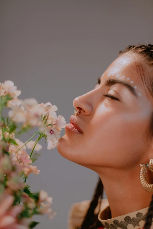 a woman is smelling a bouquet of flowers