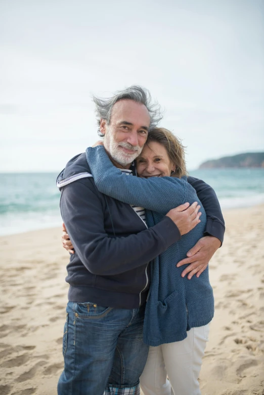 two people on the beach hugging each other