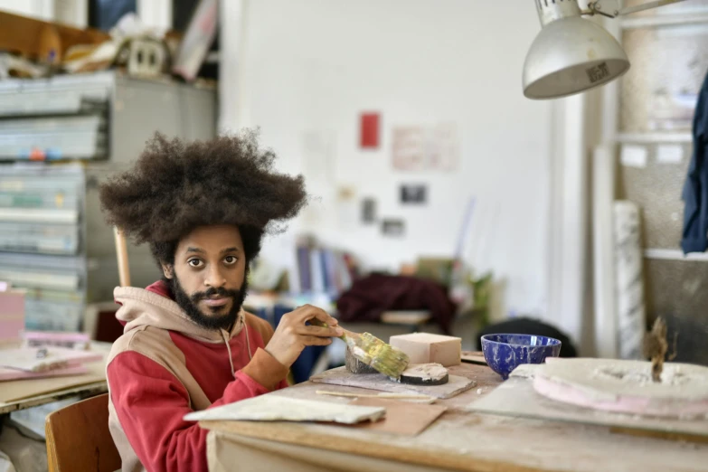 a man in red shirt holding up a brush