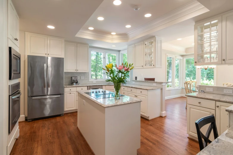 a white kitchen has stainless steel appliances and a breakfast bar