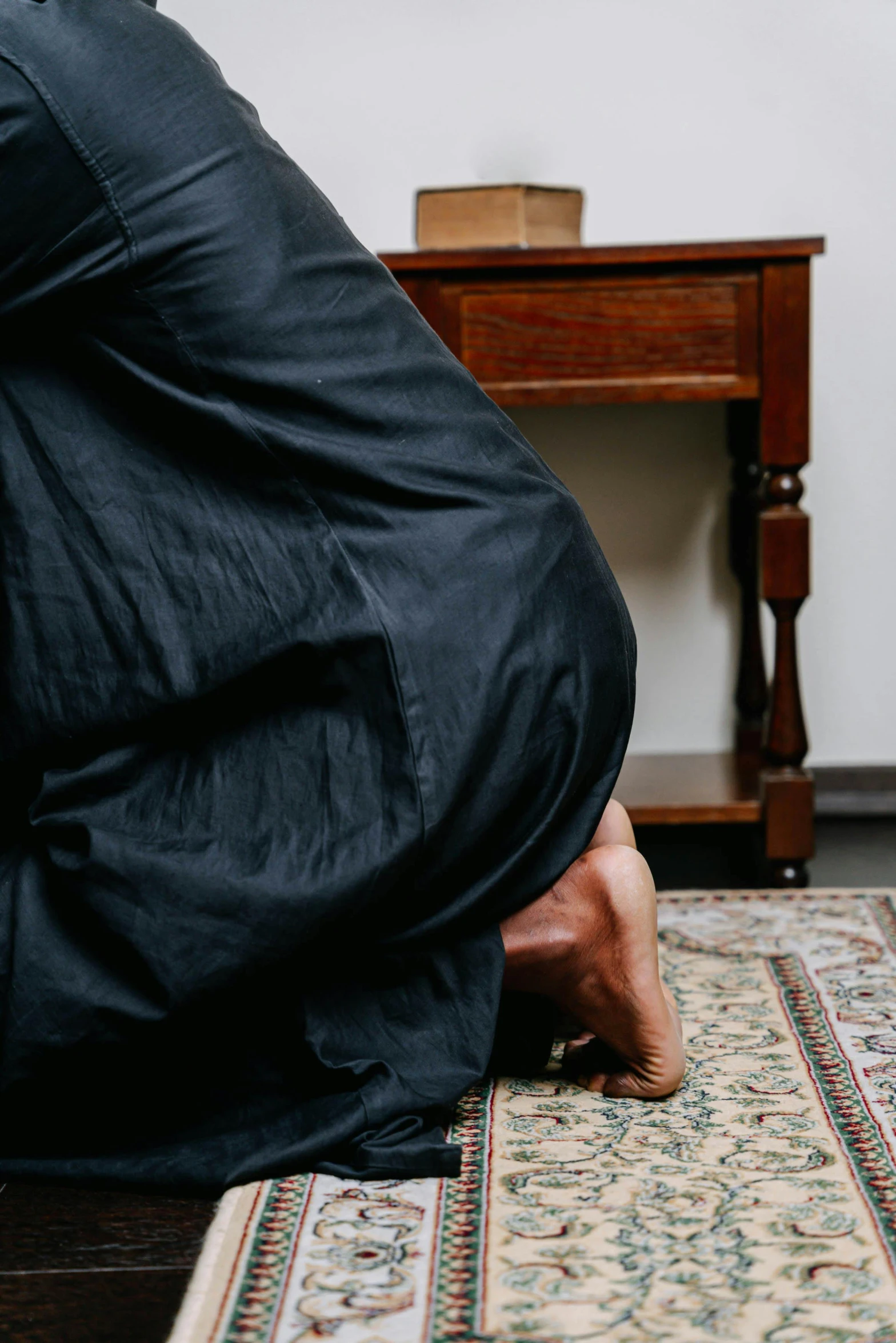 a man covers himself with an overstuffed sleeping bag while kneeling down