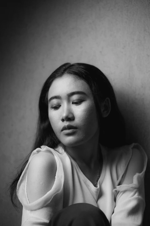 a young woman sitting on the floor with her eyes closed