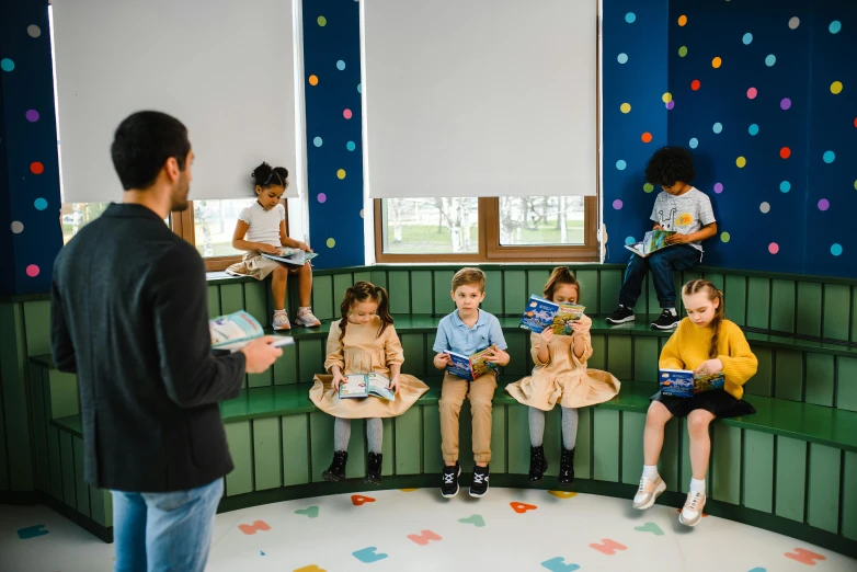 a man talking to children in school in a room