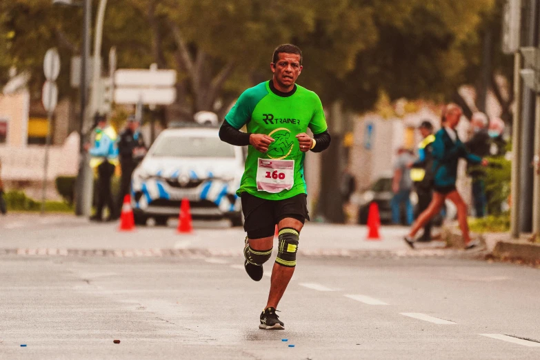 man running in the city while holding on to his knee