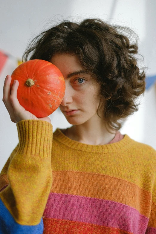 a young woman holding a piece of fruit with both hands