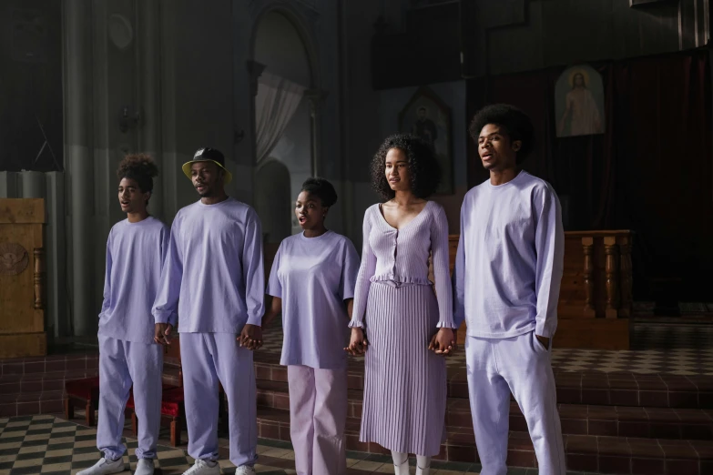 five black people wearing purple clothes standing on steps