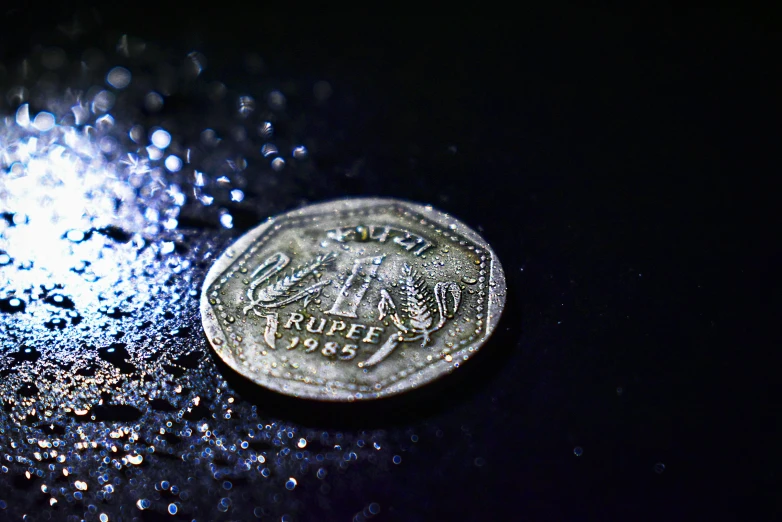 a penny sitting on a counter covered with water drops