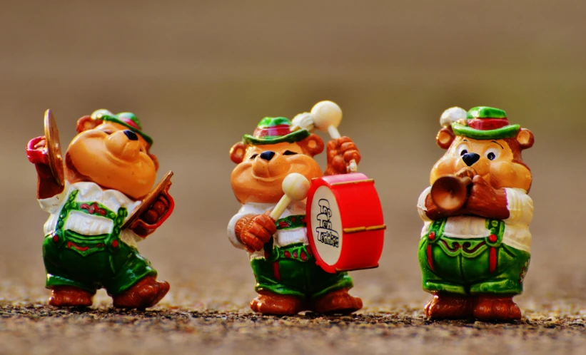 three small toy drummers dressed in various colors