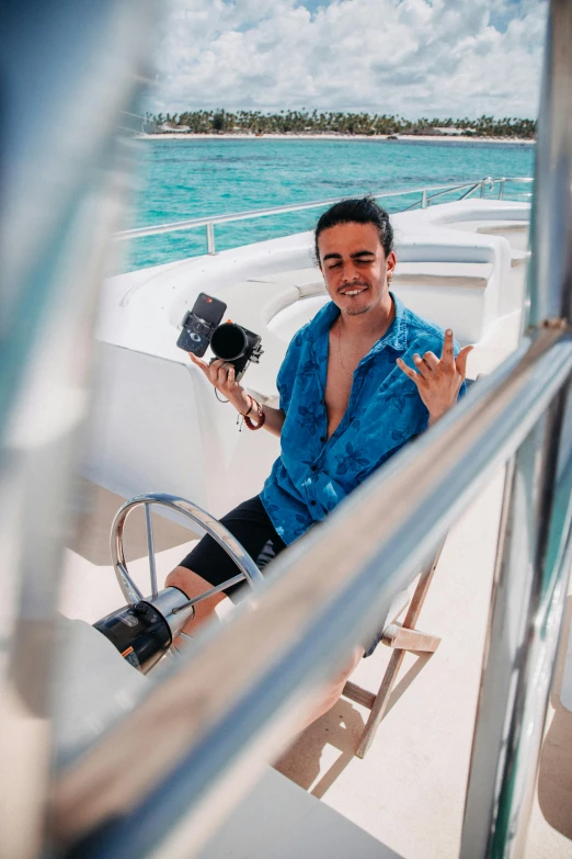 a man sitting on top of a boat next to the ocean