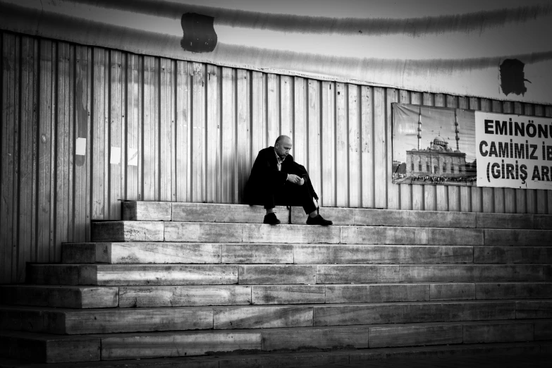 an old man sitting on top of some steps