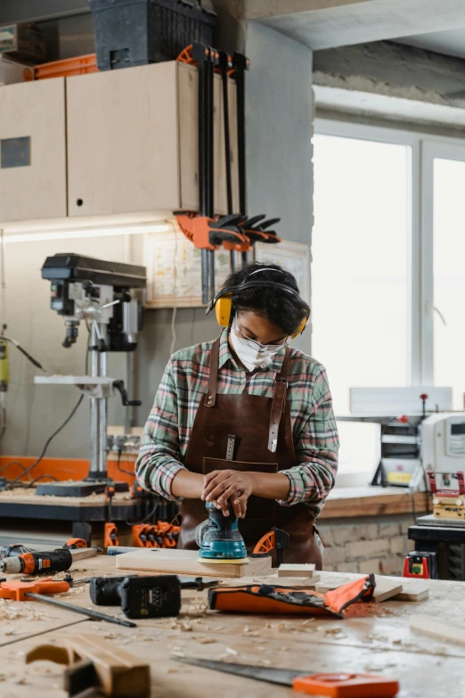 a woman working with tools on wooden planks