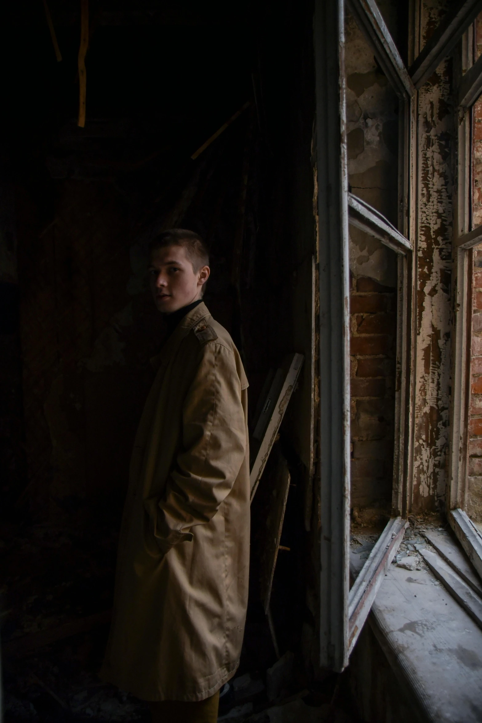 man standing in doorway with looking down at window