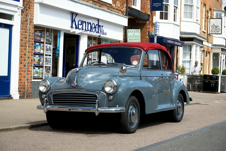 old fashion car parked on the street in front of stores