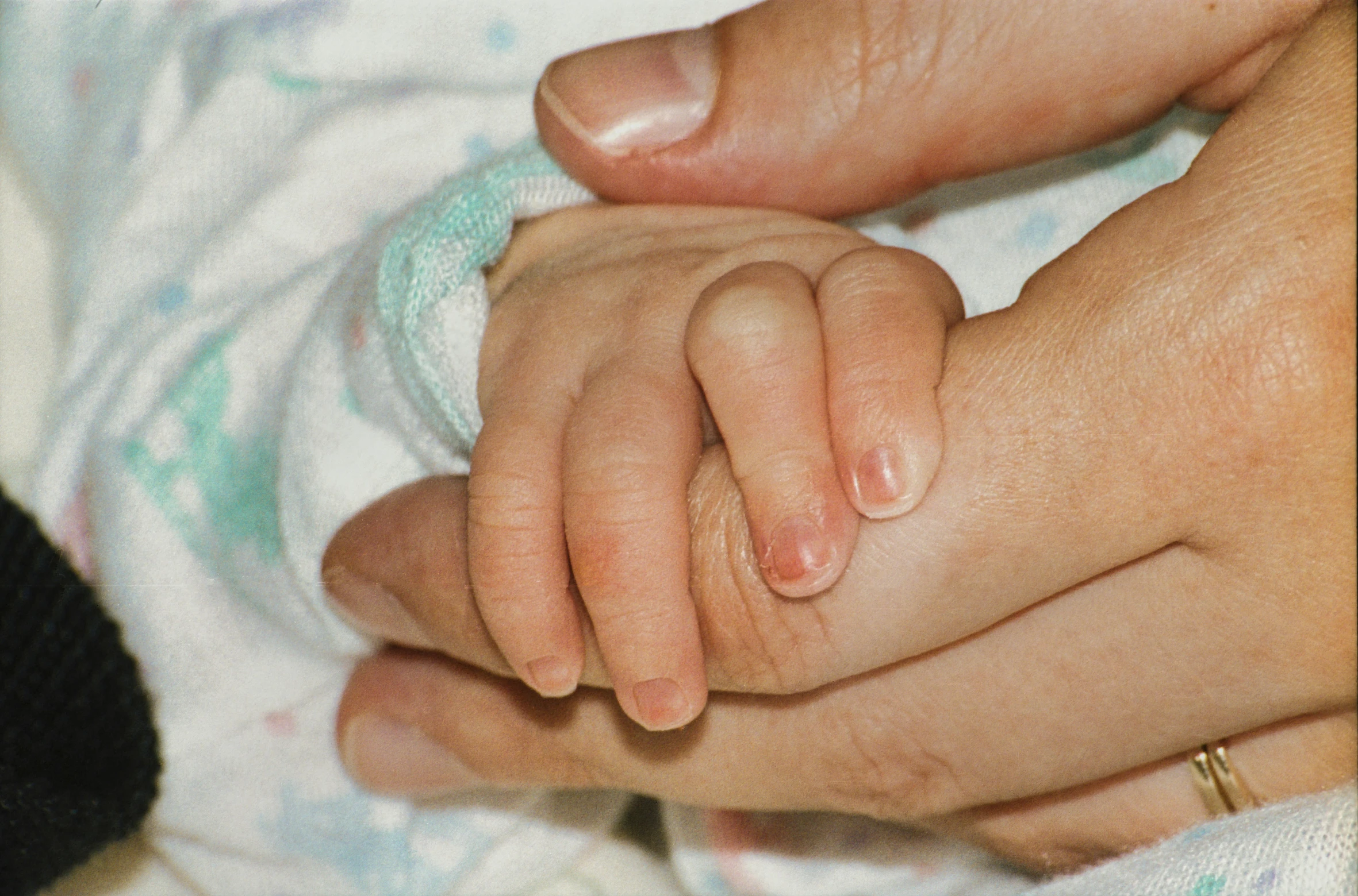 two hands holding each other in a persons lap