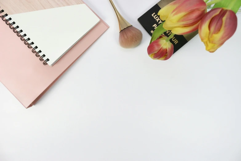 a notepad with a small brush next to it