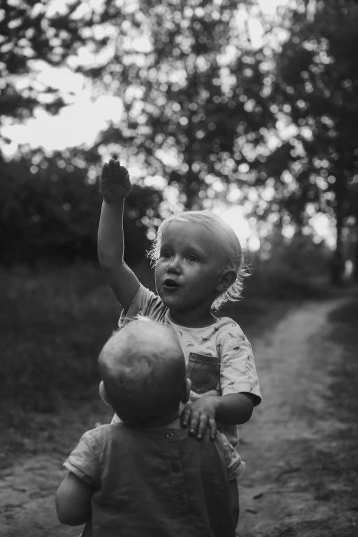 an older boy holds up a small baby ball