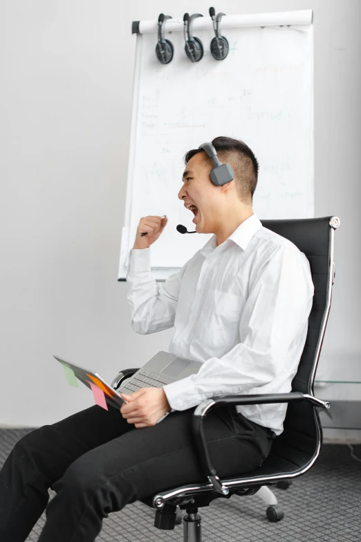 a man is on the phone while sitting in an office chair