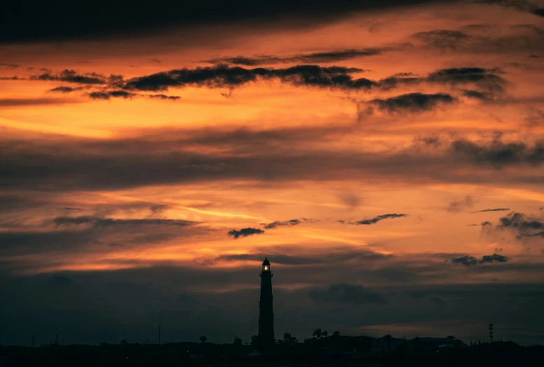 a picture of the sky above water, with a tower in the middle