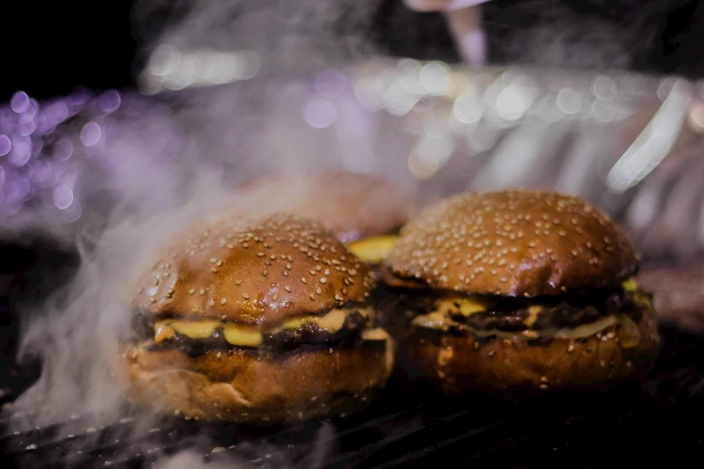 hamburgers being cooked on top of a grill