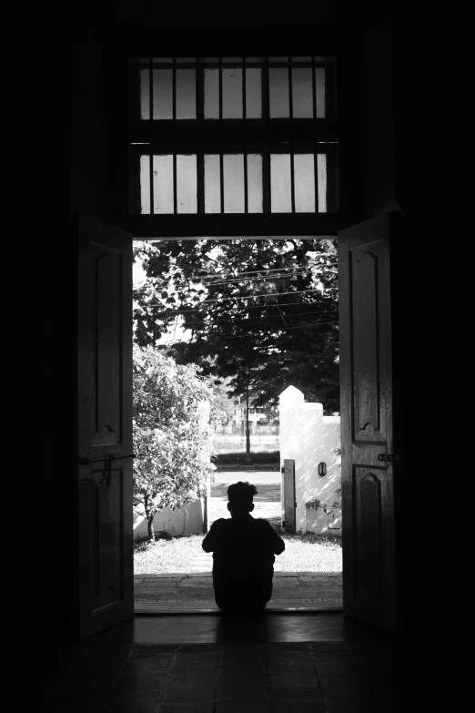 a man sitting in front of a open door