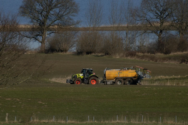 a tractor and trailer in the middle of a field