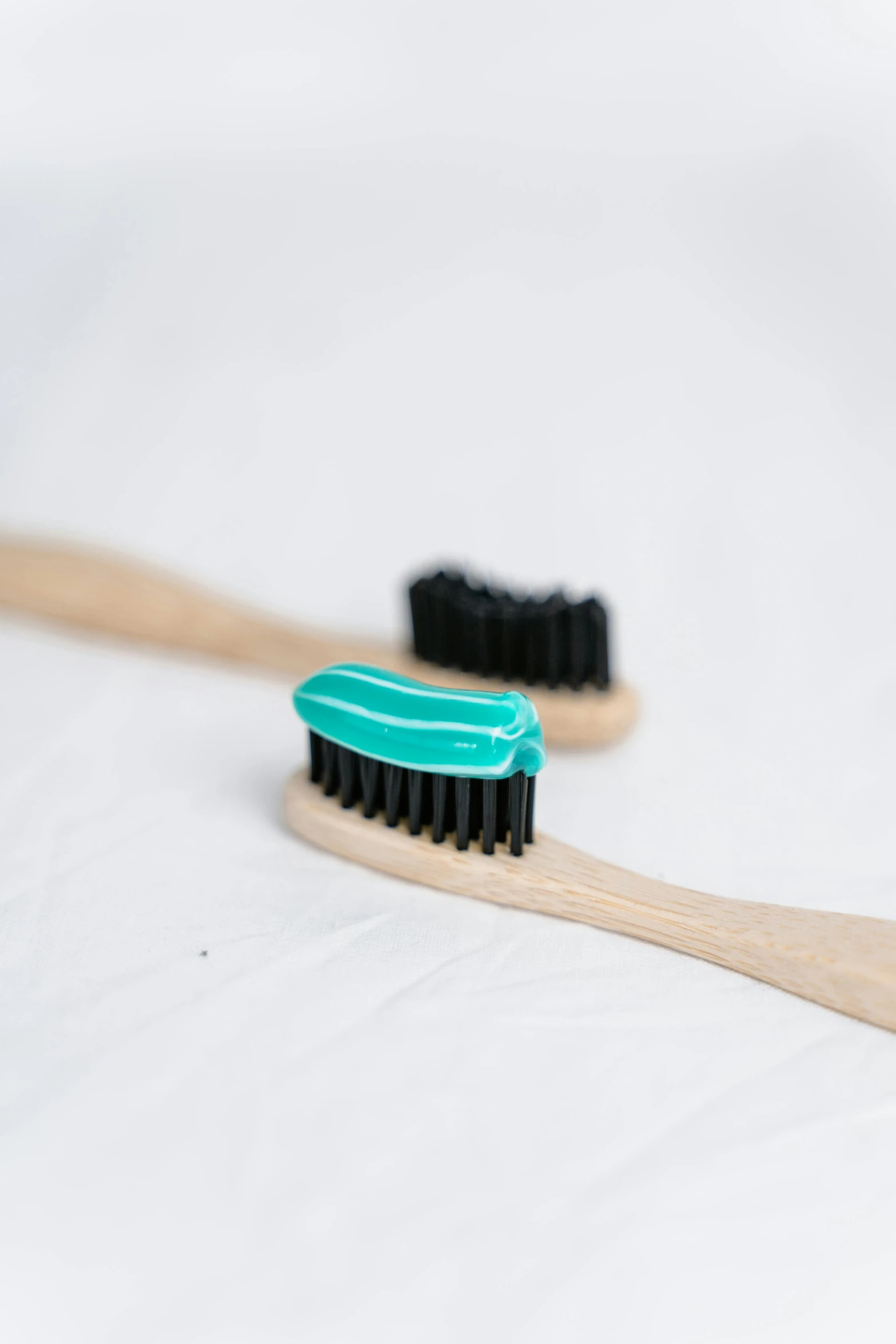 two brushes sitting next to each other on a white surface