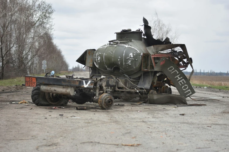 the man is next to the old tank