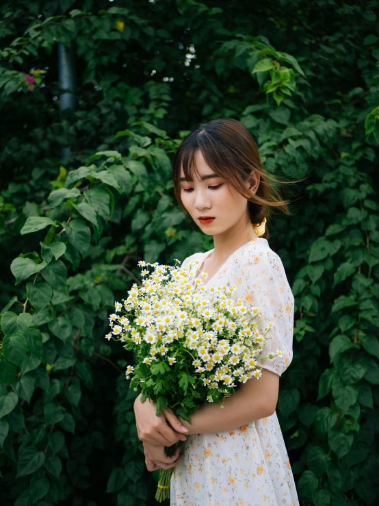 there is a woman holding a bouquet of flowers