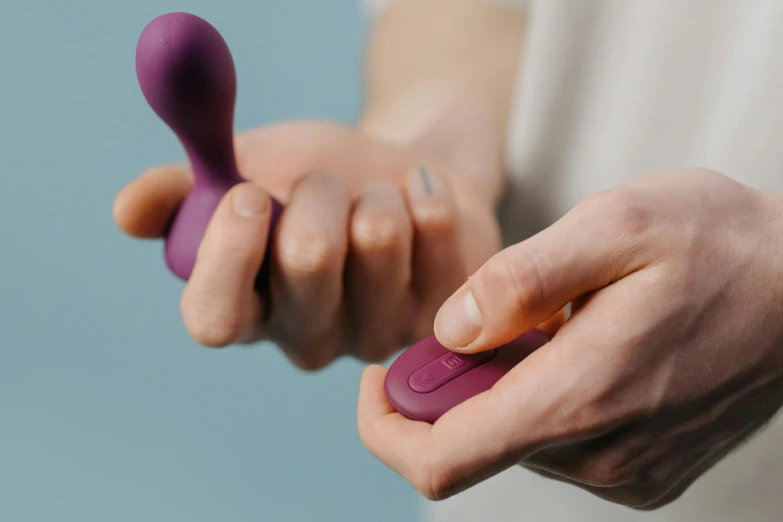 a man is holding up a purple object