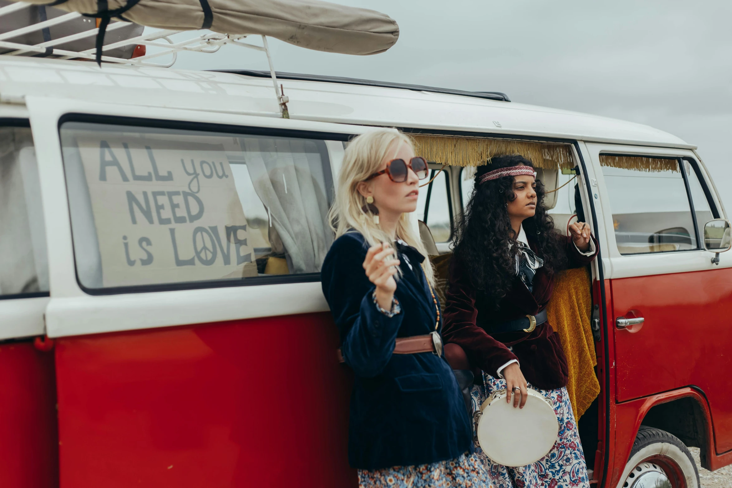 two women are standing in front of a van with their hats on