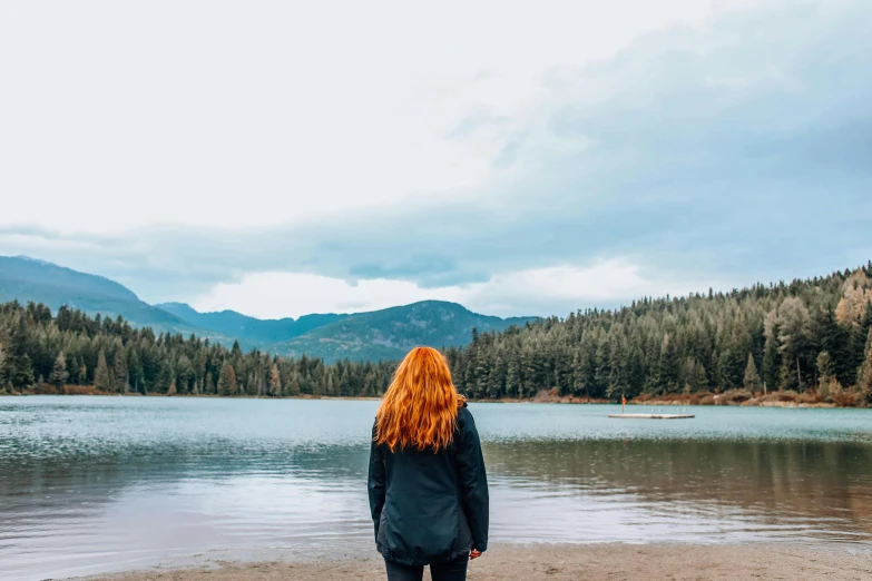 a woman standing by a body of water